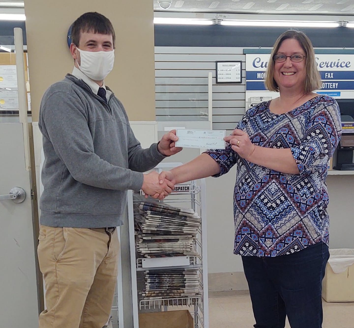 Capri IGA Manager Tyler Adams presents a check to Bond County Senior Center Director Jill Ohnesorge.