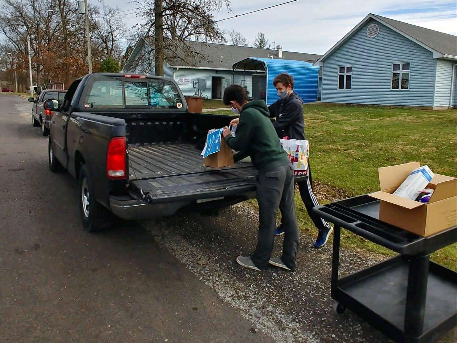 Bond County Food Pantry volunteers load shelf stable food items into a client's truckbed